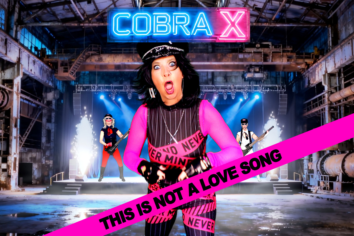 Female Artist Cobra X is singing the cover song "This Is Not a Love Song" by PiL wildly with a punk attitude. In the background, the name “COBRA X” glows in neon colors. Cobra X is wearing a tight black suit with a pink sash that reads “NEVER MIND,” a reference to the British band Sex Pistols' studio album, *Never Mind the Bollocks, Here’s the Sex Pistols*. The photo is taken from the official music video in 4K.